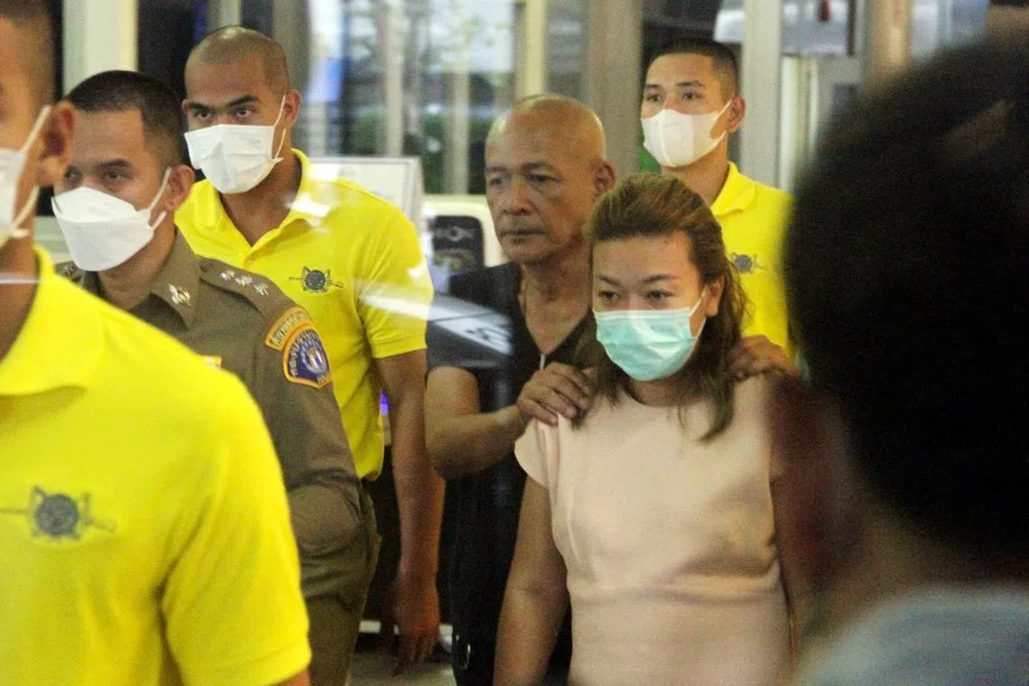 Sararat Rangsiwuthaporn, a suspect in over a dozen murders, is escorted by police officers at a police station in Bangkok on Apr 26, 2023. 