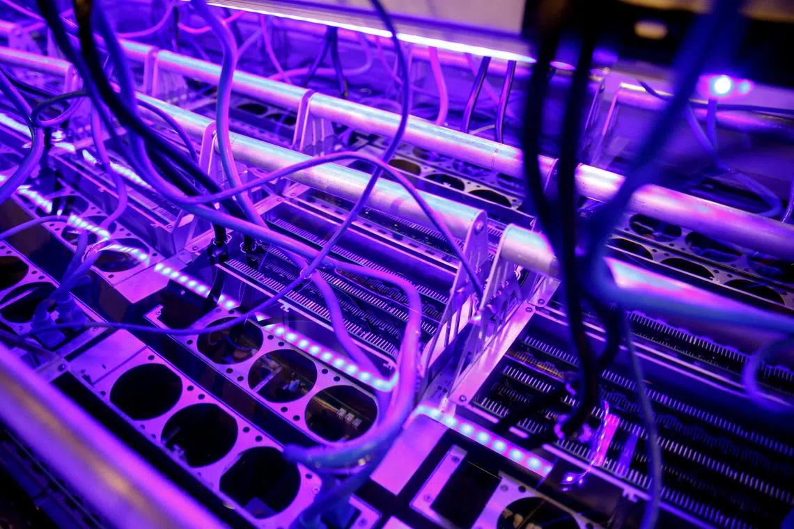 FILE PHOTO: Cryptocurrency miners are seen in a liquid immersion cooling mining tank at the TMG Core stand during the Bitcoin Conference 2022 in Miami Beach, Florida, U.S. April 6, 2022. REUTERS/Marco Bello/File Photo