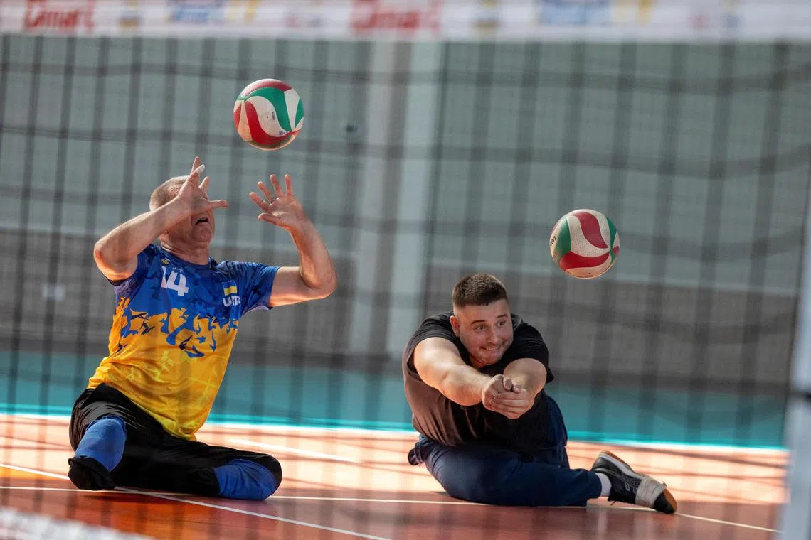 Former Ukrainian serviceman Yevhenii Korinets (right) and a fellow member of Ukraine's sitting volleyball Paralympic team practising at a gym in Reshetylivka, Ukraine, on Aug 7.