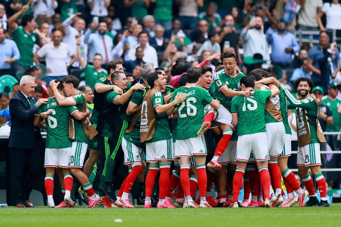 Mexico's Julian Quinones celebrating scoring their first goal with team-mates and coach Javier Aguirre on June 11. 