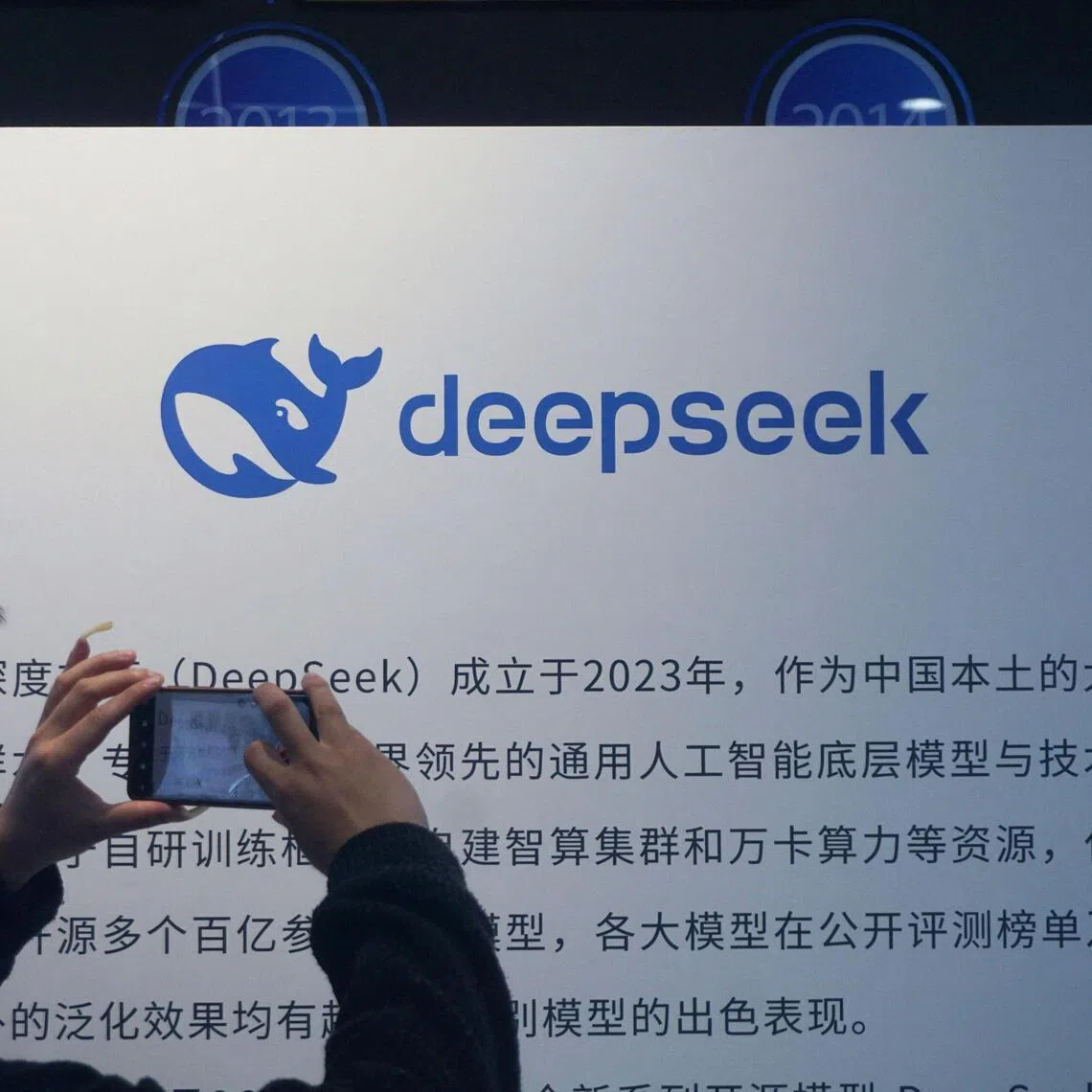 A man takes photos of a DeepSeek display at a shopping mall in Hangzhou, in China’s eastern Zhejiang province on April 23, 2026. Chinese startup DeepSeek released a new artificial intelligence model with "drastically reduced" costs on April 24, more than a year after it stunned the world with a low-cost reasoning model that matched the capabilities of US rivals. (Photo by CN-STR / AFP) / China OUT