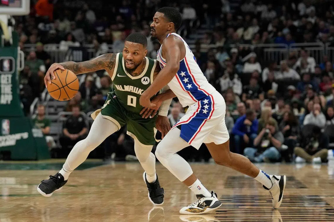 Damian Lillard of the Milwaukee Bucks dribbling the ball against De'Anthony Melton of the Philadelphia 76ers in the first half at Fiserv Forum.