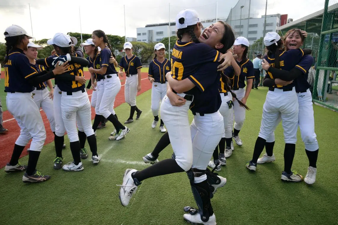 Methodist Girls' School softball team vice-captain Maeko Sng (right) celebrates captain Shona Abay Gunalan after the school retained their B Division title on March 11, 2025.