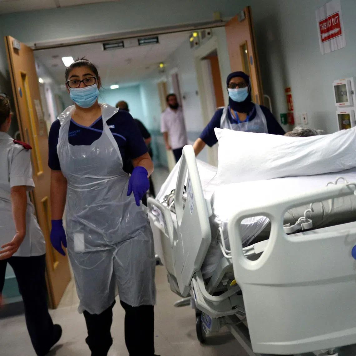 Medical staff transfer a patient along a hospital corridor in this May 14, 2020 file photo as the Covid-19 virus began spreading rapidly across Britain.