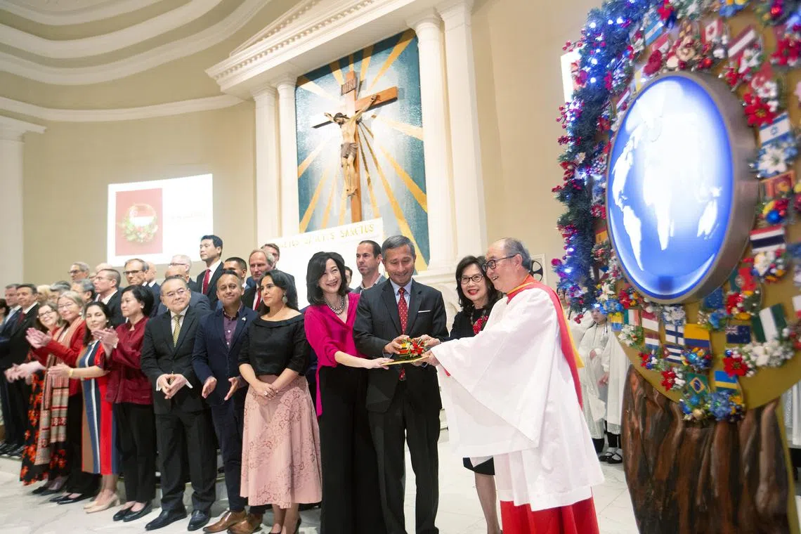 Foreign Minister Vivian Balakrishnan and his wife Joy (third and fourth from right) turning on the lights on the “tree of peace”, together with the choir’s founder-director Sir Dr Peter Low and his wife Linda.