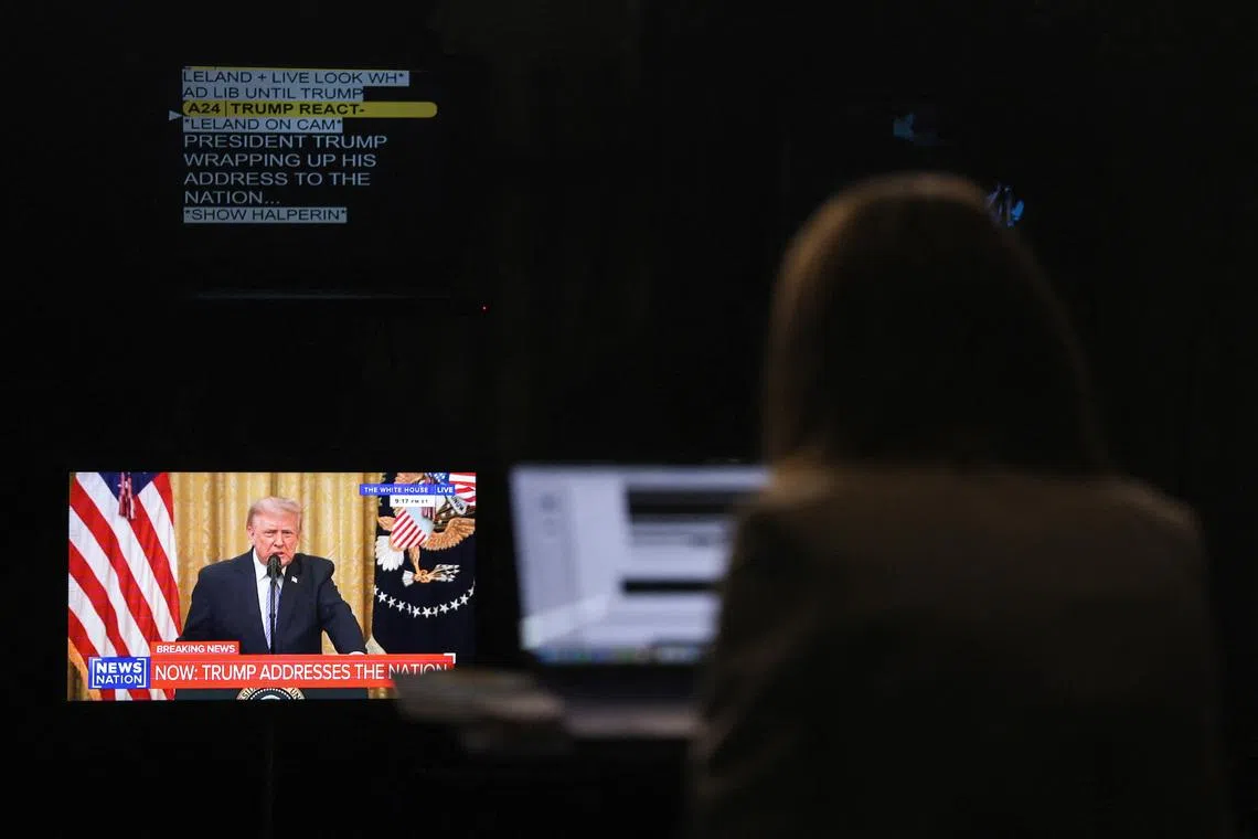 A journalist works as a screen displays U.S. President Donald Trump speaking about election security during an address to the nation from the East Room of the White House, in Washington, D.C., U.S., July 16, 2026. REUTERS/Kylie Cooper