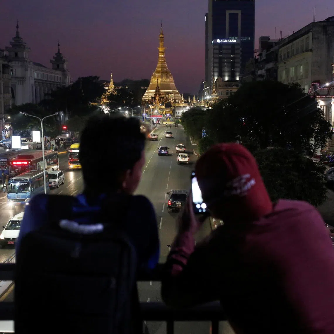 FILE PHOTO: Two boys take photos of the Sule Pagoda during sunset hours in Yangon, Myanmar, January 23, 2020. REUTERS/Ann Wang/File photo