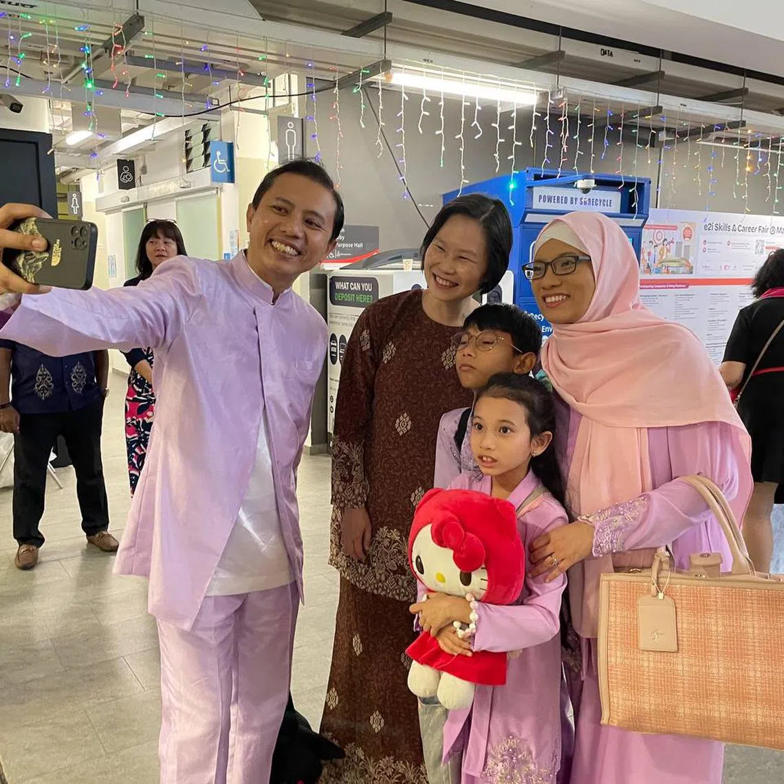 Minister of State for Manpower and Education Gan Siow Huang taking photos with residents at a Hari Raya celebration at Marymount CC on April 20.