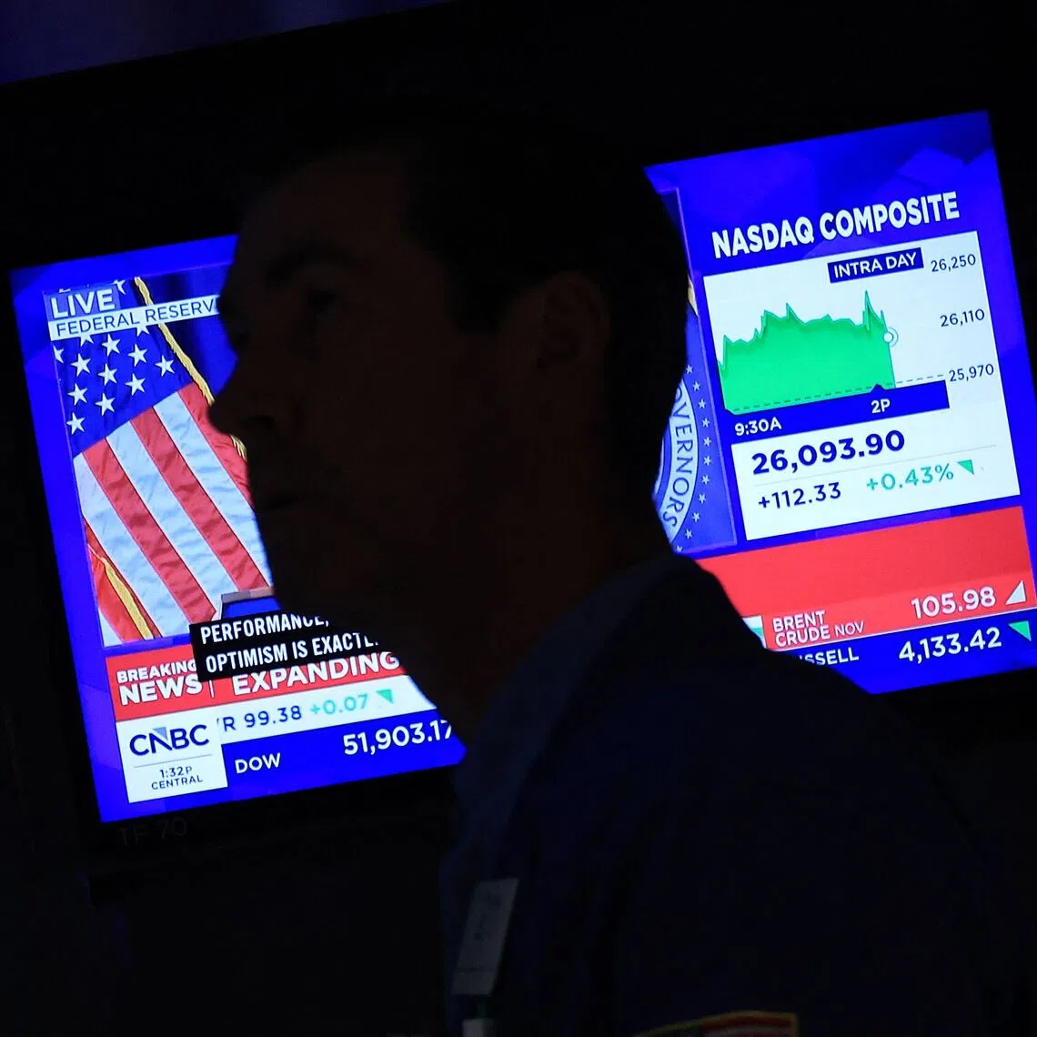 Traders work on the floor of the New York Stock Exchange as a screen broadcasts news on the US Federal Reserve’s interest rate hike in New York City, Sept 16.