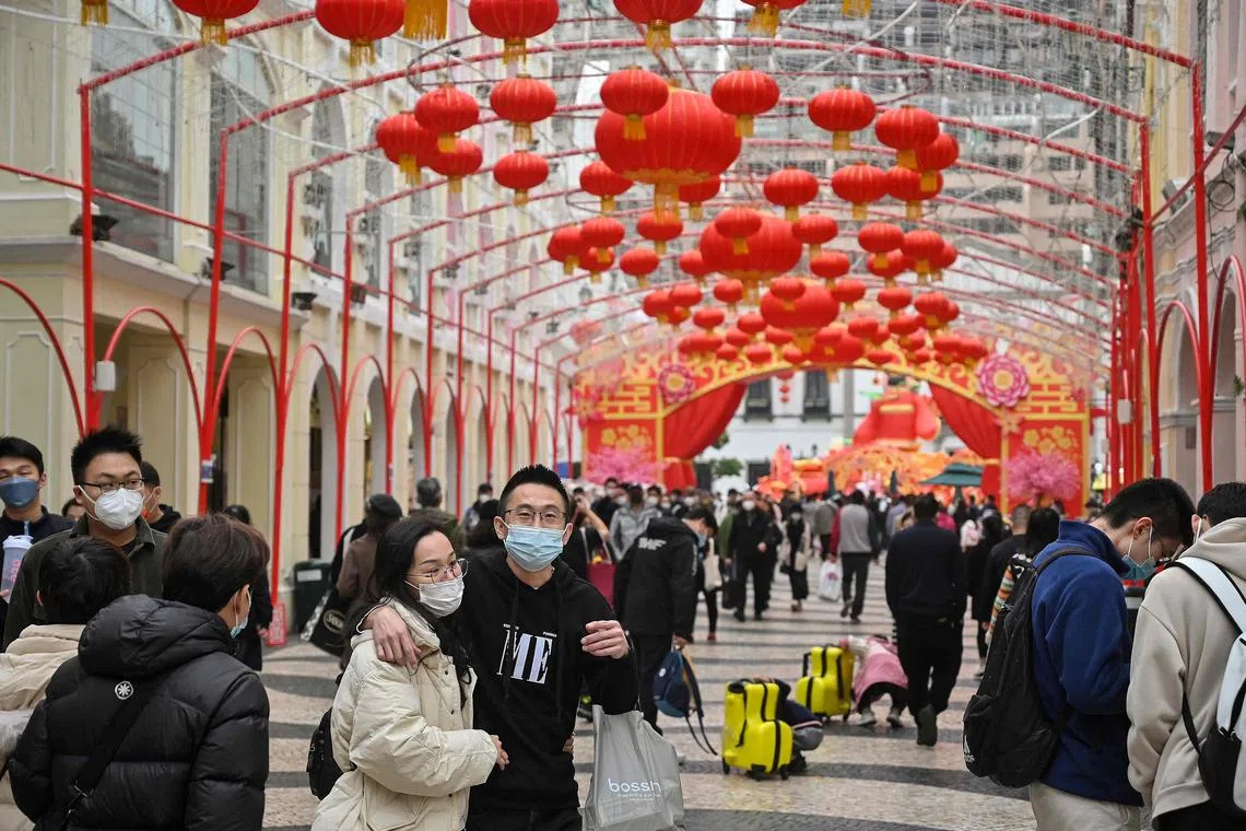 This photo taken on Jan 17, 2023 shows Chinese tourists strolling down a street in Macau. 