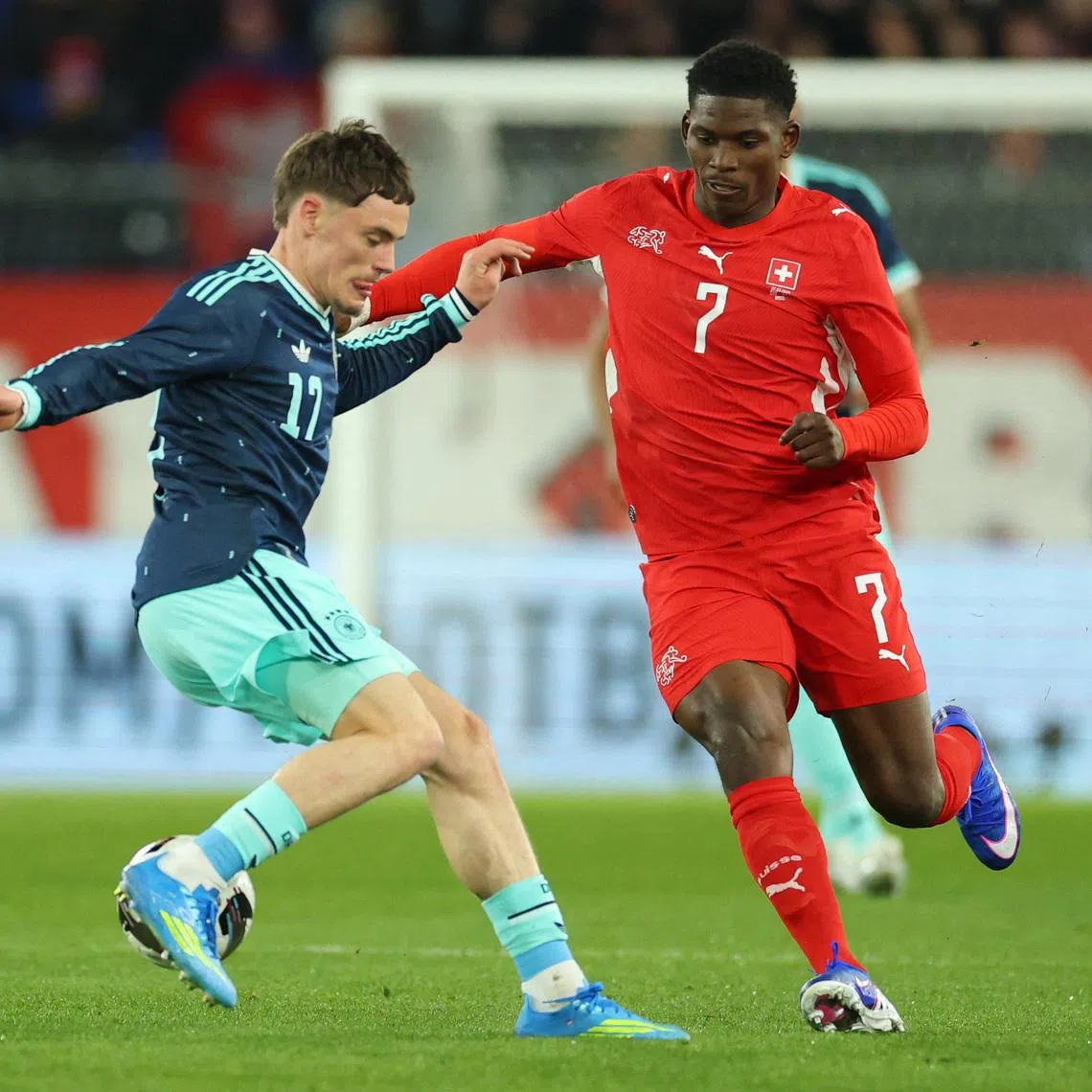 Soccer Football - International Friendly - Switzerland v Germany - St. Jakob-Park, Basel, Switzerland - March 27, 2026 Germany's Florian Wirtz in action with Switzerland's Breel Embolo REUTERS/Denis Balibouse