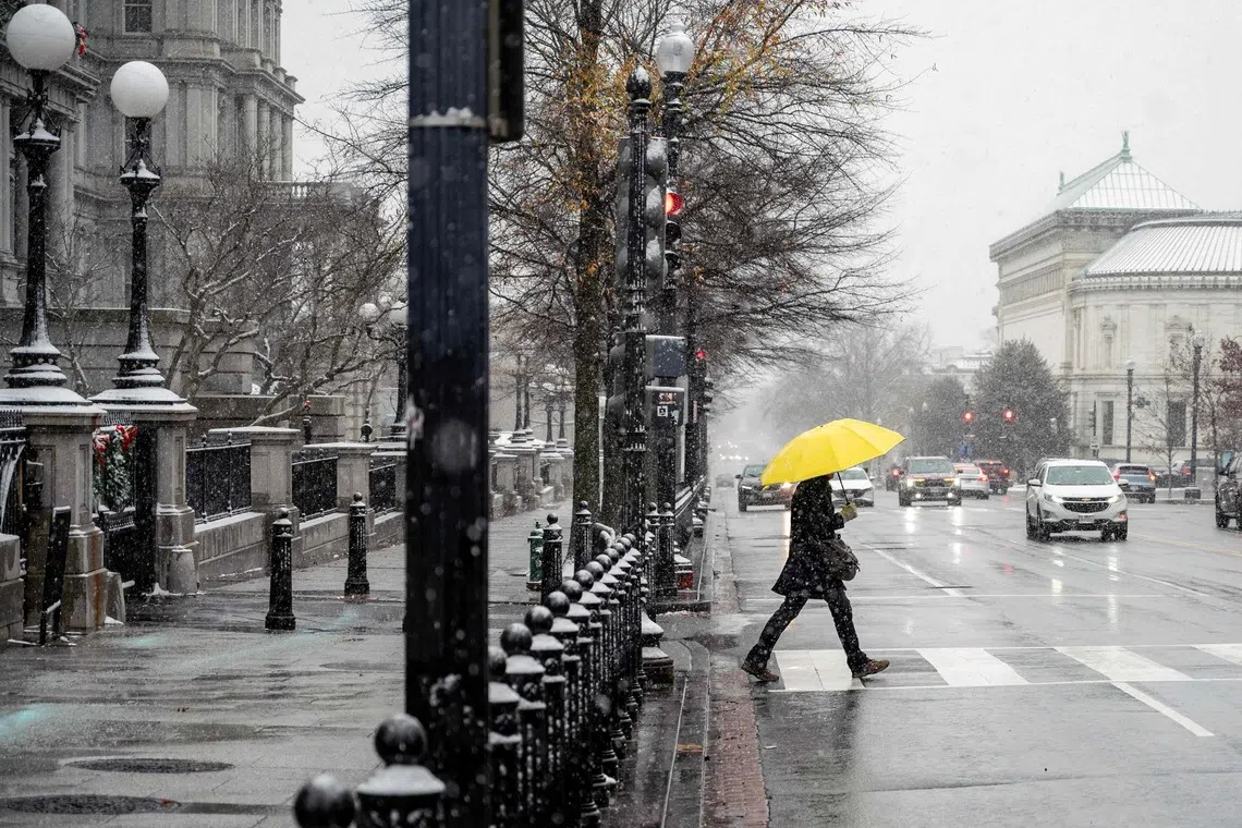 A man crosses an intersection in downtown Washington on Dec 6. The Arctic chill was expected to persist in waves over the next week or two.