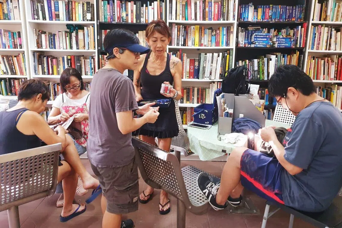 sslibrary27 - Visitors browsing through books at the void deck library, HV Little Library, at Blk 2 Holland Avenue. 

Credit: HV Little Library