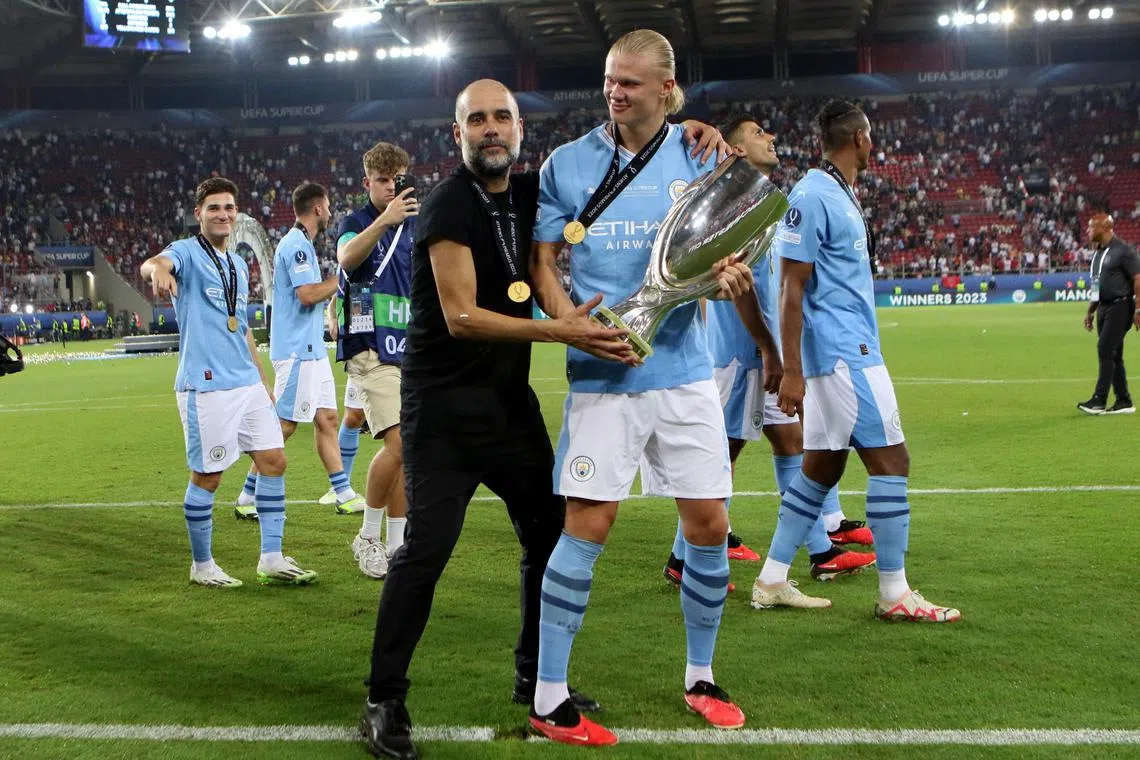 Manchester City manager Pep Guardiola and striker Erling Haaland celebrate winning the Uefa Super Cup.
