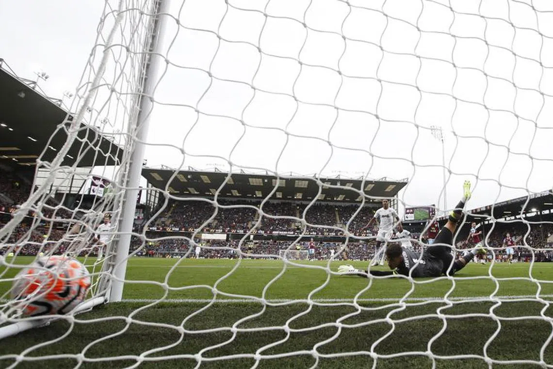 Soccer Football - Premier League - Burnley v Aston Villa - Turf Moor, Burnley, Britain - August 27, 2023 Aston Villa's Moussa Diaby scores their third goal past Burnley's James Trafford REUTERS/Molly Darlington