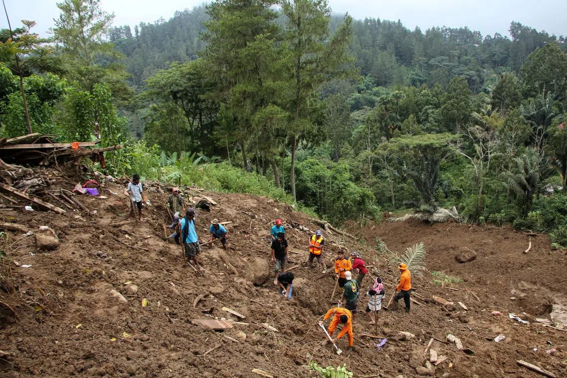 Indonesian rescue members and residents evacuate people from a landslide site in Tana Toraja on April 15.