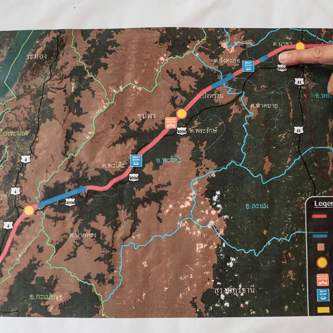 Chalermusa Seekhiao, 56, points at a map showing the route of Thailand's proposed Southern Land Bridge project, a route linking Ranong and Chumphon provinces, as part of Thailand’s proposed Southern Land Bridge project to connect the Andaman Sea and the Gulf of Thailand, in Phato district, Chumphon province, Thailand, May 18, 2026. REUTERS/Chalinee Thirasupa