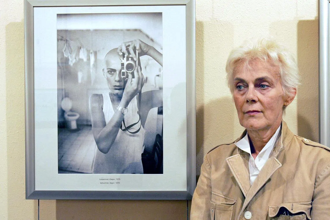 French press photographer Marie-Laure de Decker poses next to a self-portrait of her exhibition presented at the "Couvent des Minimes" during the 18th Festival International of Photojournalism "Visa pour l'image",  on Sept 6, 2006, in Perpignan. 