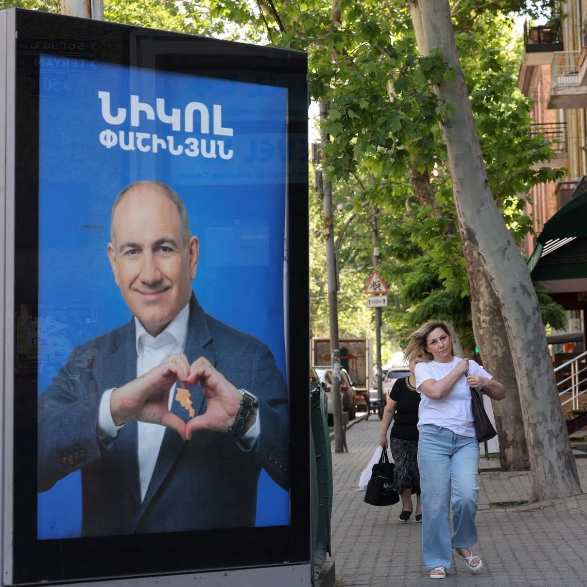 FILE PHOTO: People walk past campaign banners with portraits of Prime Minister Nikol Pashinyan of the Civil Contract party, ahead of the June 7 parliamentary election, in Yerevan, Armenia June 3, 2026. Hayk Baghdasaryan/Photolure via REUTERS/File Photo