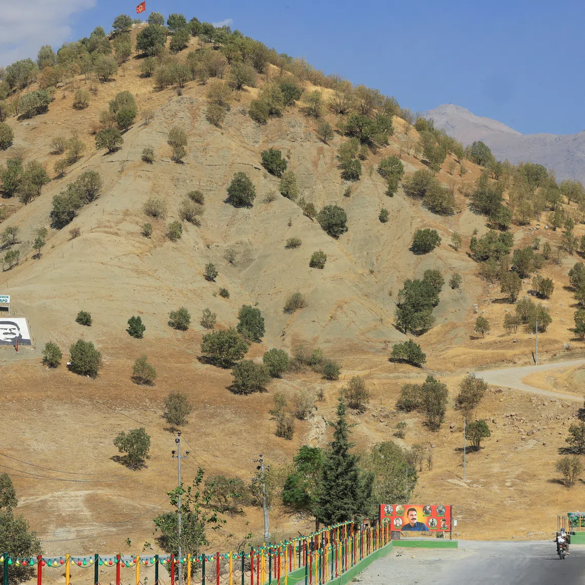 A portrait of jailed Kurdistan Workers Party (PKK) leader Abdullah Ocalan and a sign with the words \"Serok Apo,\" are displayed on a hillside in the Qandil mountains, Iraq, October 26, 2025. REUTERS/Thaier Al-Sudani