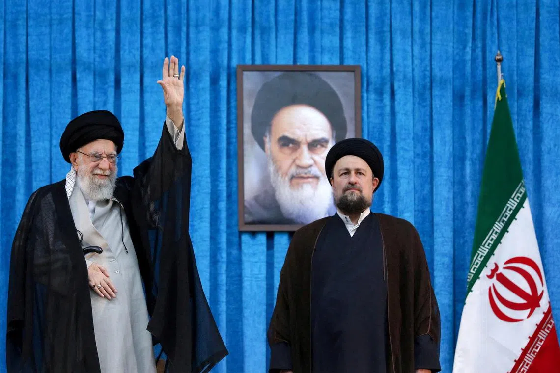 Mr Hassan Khomeini (right) stands next to Iran's Supreme Leader Ayatollah Ali Khamenei.