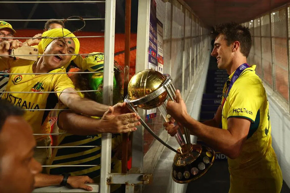 Cricket - ICC Cricket World Cup 2023 - Final - India v Australia - Narendra Modi Stadium, Ahmedabad, India - November 19, 2023 Australia's Pat Cummins celebrates with fans and the trophy after winning the ICC Cricket World Cup REUTERS/Andrew Boyers