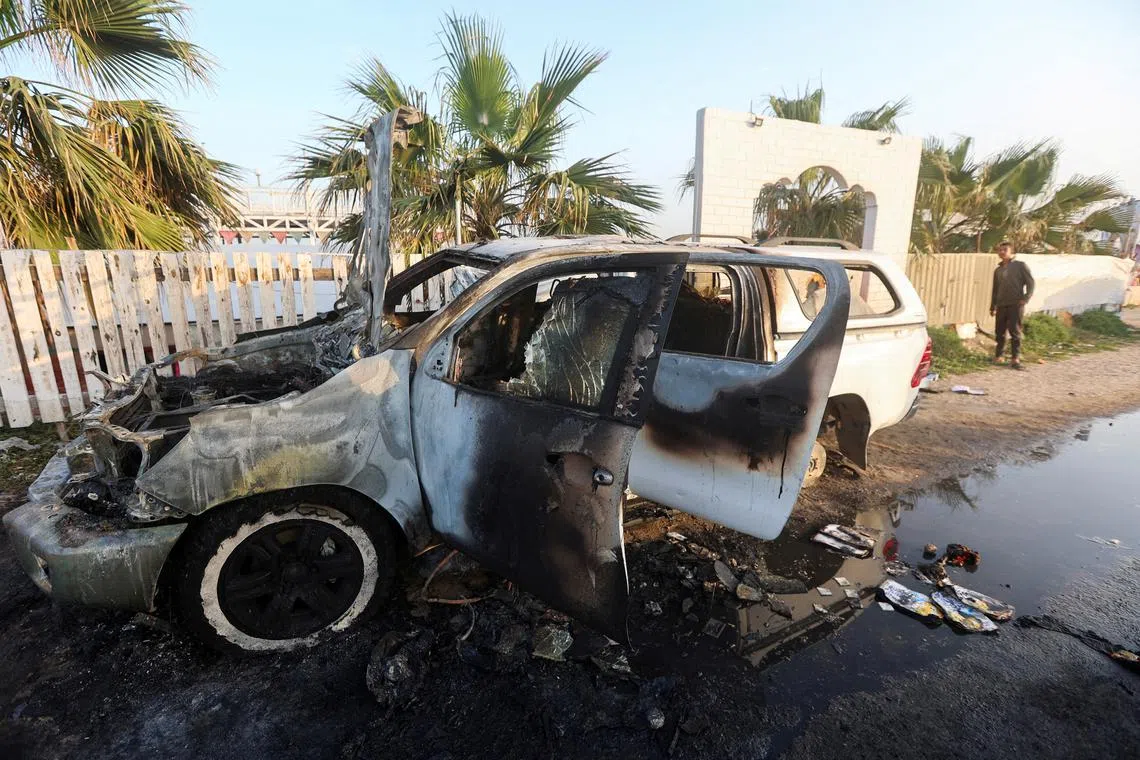 FILE PHOTO: A person looks at a vehicle where employees from the World Central Kitchen (WCK), including foreigners, were killed in an Israeli airstrike, according to the NGO as the Israeli military said it was conducting a thorough review at the highest levels to understand the circumstances of this \"tragic\" incident, amid the ongoing conflict between Israel and Hamas, in Deir Al-Balah, in the central Gaza, Strip April 2, 2024. REUTERS/Ahmed Zakot//File Photo
