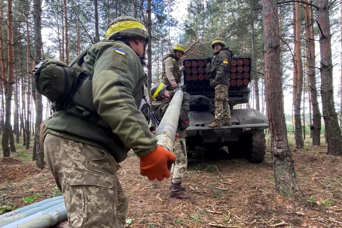 Ukrainian servicemen load a rocket after firing at a frontline on the border of Kharkiv and Luhansk regions.
