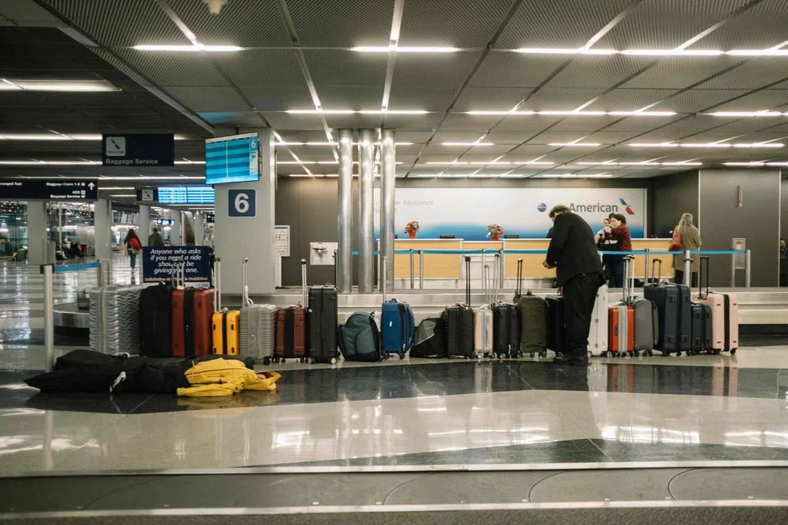 CHICAGO, ILLINOIS - JANUARY 12: A worker collects and scans unclaimed luggage at O'Hare Airport on January 12, 2024 in Chicago, Illinois. Over 1,900 flights have been canceled nationwide due to a large winter storm bringing blizzard conditions.   Jim Vondruska/Getty Images/AFP (Photo by Jim Vondruska / GETTY IMAGES NORTH AMERICA / Getty Images via AFP)