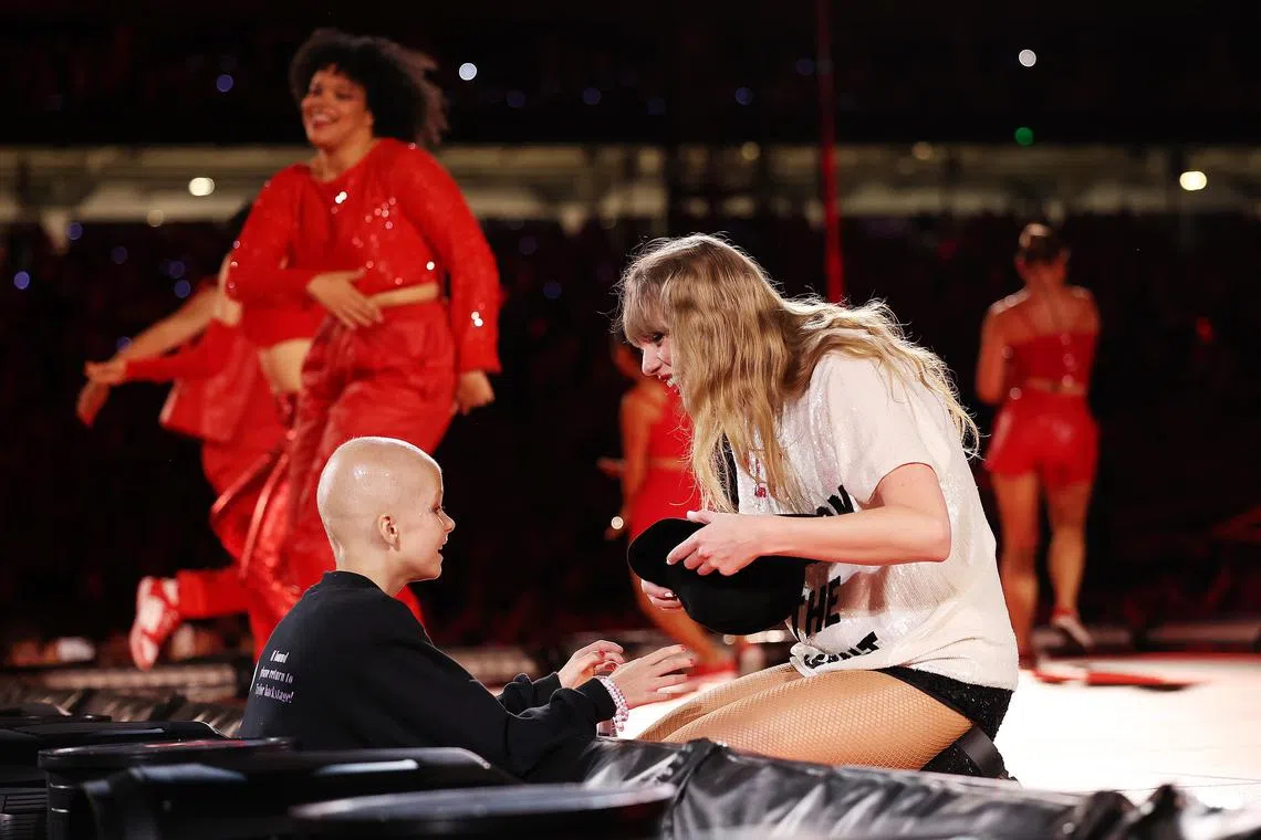 Scarlett Oliver receives the "22 hat" from Taylor Swift during her performance at Accor Stadium on Feb 23, 2024 in Sydney, Australia. 