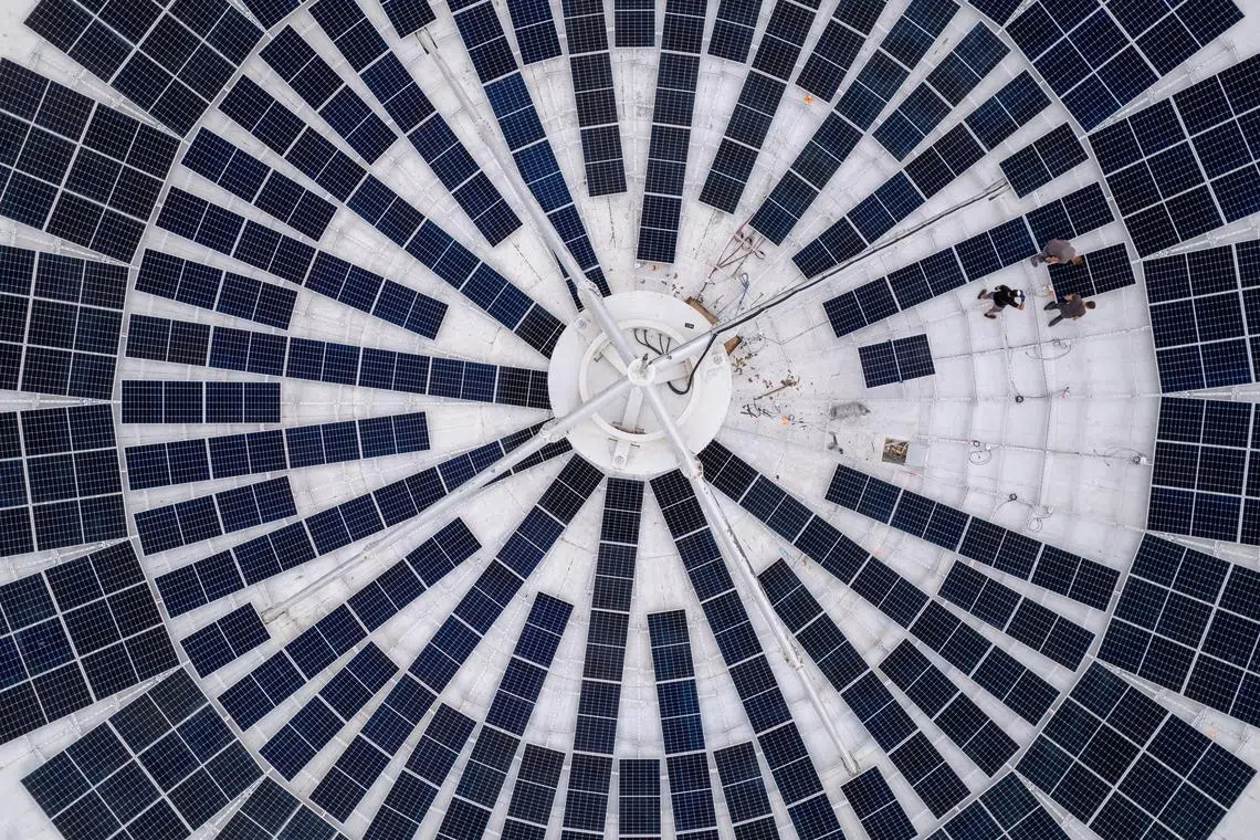 Employees of Swiss electricity producer and supplier CKW, part of Axpo, install solar panels in a satellite dish at the Leuk Teleport and Data Center in Leuk, Switzerland, October 18, 2023.  REUTERS/Denis Balibouse
