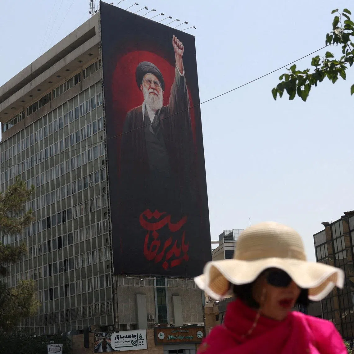 A woman walks by a billboard depicting Iran's late Supreme Leader Ayatollah Ali Khamenei, on a street in Tehran, Iran, July 21, 2026.  Majid Asgaripour/WANA (West Asia News Agency) via REUTERS