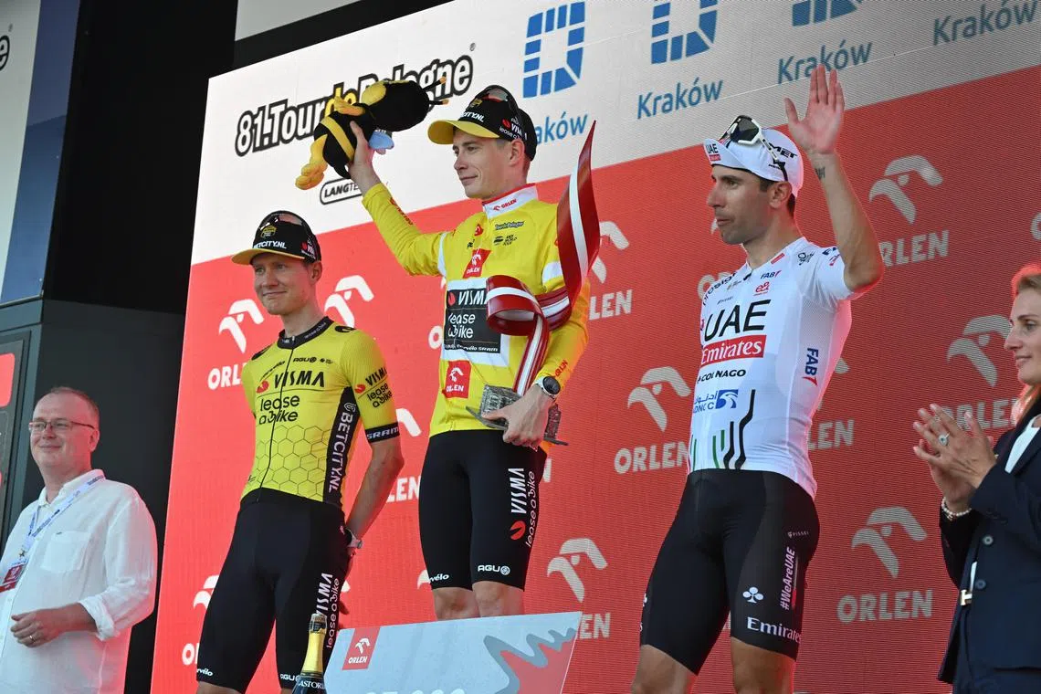 Tour of Poland winner, Danish rider Jonas Vingegaard of Visma-Lease a Bike team, flanked by third-placed Dutchman Wilco Kelderman (left) of Visma-Lease a Bike, and second-placed Italian Diego Ulissi of UAE Team Emirates team, celebrates on the podium after the seventh and last stage over 142 km, from Wieliczka to Krakow, on Aug 18, 2024.