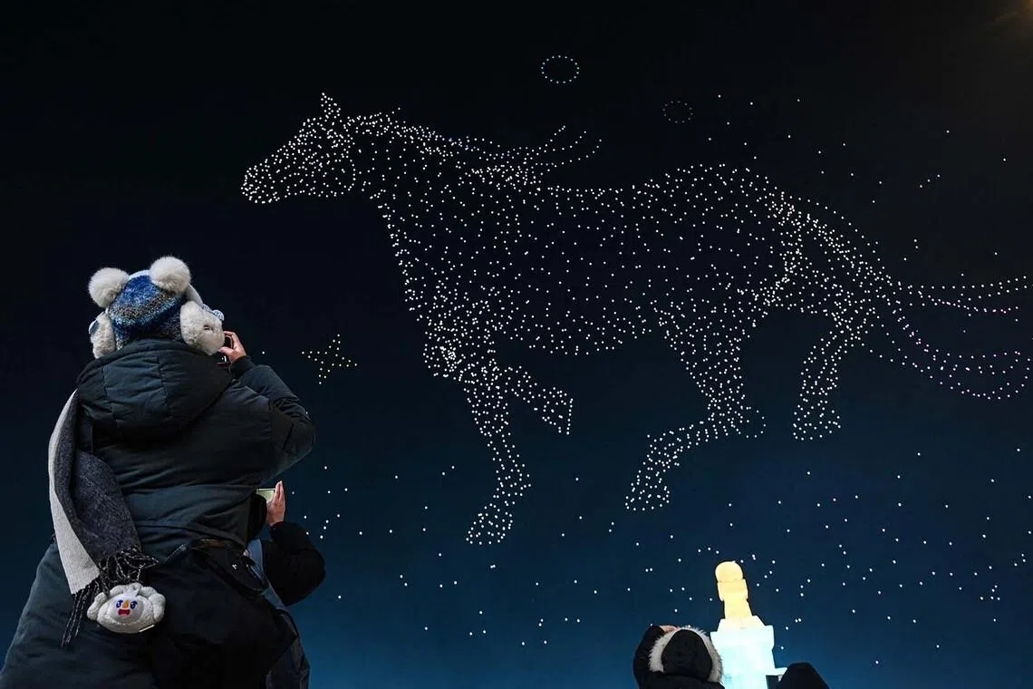 People taking photos during a drone show at the opening ceremony of the 42nd Harbin China International Ice and Snow Festival at Harbin in northeastern China’s Heilongjiang province on Jan 5, 2026. 