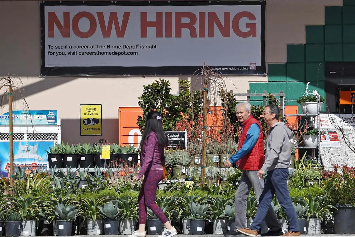 (FILES) Home Depot customers walk by a posted now hiring sign on March 8, 2024 in San Rafael, California. US hiring rose much more than expected in March, according to government data published on April 5, 2024, keeping up the pressure on the Federal Reserve as it weighs when to start cutting interest rates. The world's largest economy added 303,000 jobs in March, up sharply from a month earlier, the Department of Labor announced. The unemployment rate ticked lower to 3.8 percent. (Photo by JUSTIN SULLIVAN / GETTY IMAGES NORTH AMERICA / AFP)
