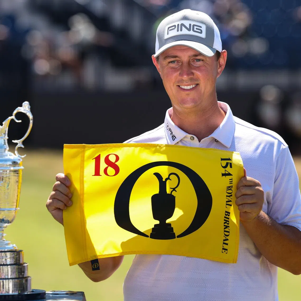 Jul 13, 2026; Southport, England; Joe Dean poses with an eighteenth hole flag alongside the Claret Jug as he wins the Last Qualifier for The Open Championship golf tournament at Royal Birkdale. Mandatory Credit: Bill Streicher-Imagn Images