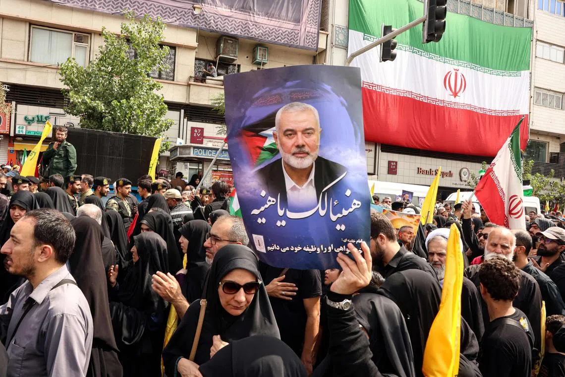 Iranians hold portraits of late Hamas leader Ismail Haniyeh during his funeral procession, in Tehran, on Aug 1, ahead of his burial in Qatar.