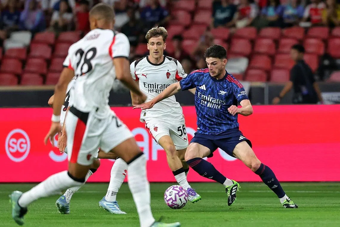Declan Rice (right) of Arsenal bringing the ball upfield in a pre-season friendly against AC Milan at the National Stadium on July 23, 2025. ST PHOTO: KEVIN LIM dgsoc23