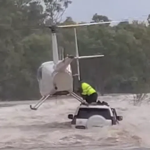 A Heli-Muster R44 helicopter perched partly on the car roof as it picked up the two men and the pet dog.