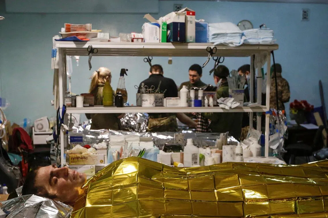 An injured Ukrainian serviceman lies inside a frontline medical stabilisation point, amid Russia's attack on Ukraine, in Donetsk region, Ukraine on April 23, 2023.   