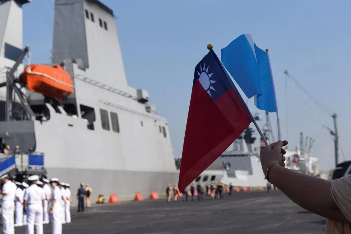 A person holds the Taiwan and Guatemala flags near the flagship warship PAN-SHI (AOE-532), one of three ships in Taiwan's Naval Friendship Squadron, arrives at Puerto Quetzal on a visit to Guatemala as part of its annual cadet training deployment, a goodwill mission aimed at strengthening ties while conducting naval exercises in Central America and the Caribbean, in Puerto Quetzal, San Jose, Escuintla, Guatemala, May 2, 2026. REUTERS/Cristina Chiquin