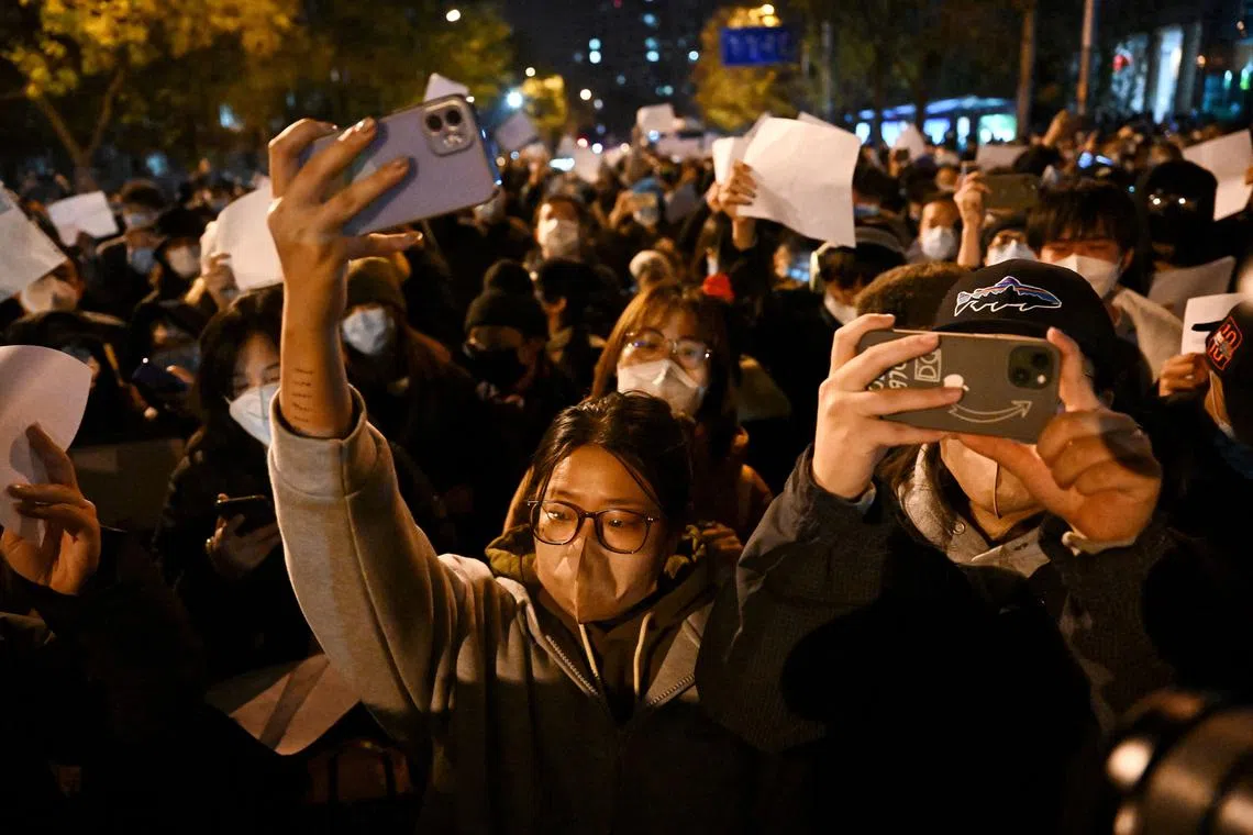 Protesters march along a street during a rally for the victims of a deadly fire as well as a protest against China's harsh Covid-19 restrictions in Beijing on Nov 28, 2022.
