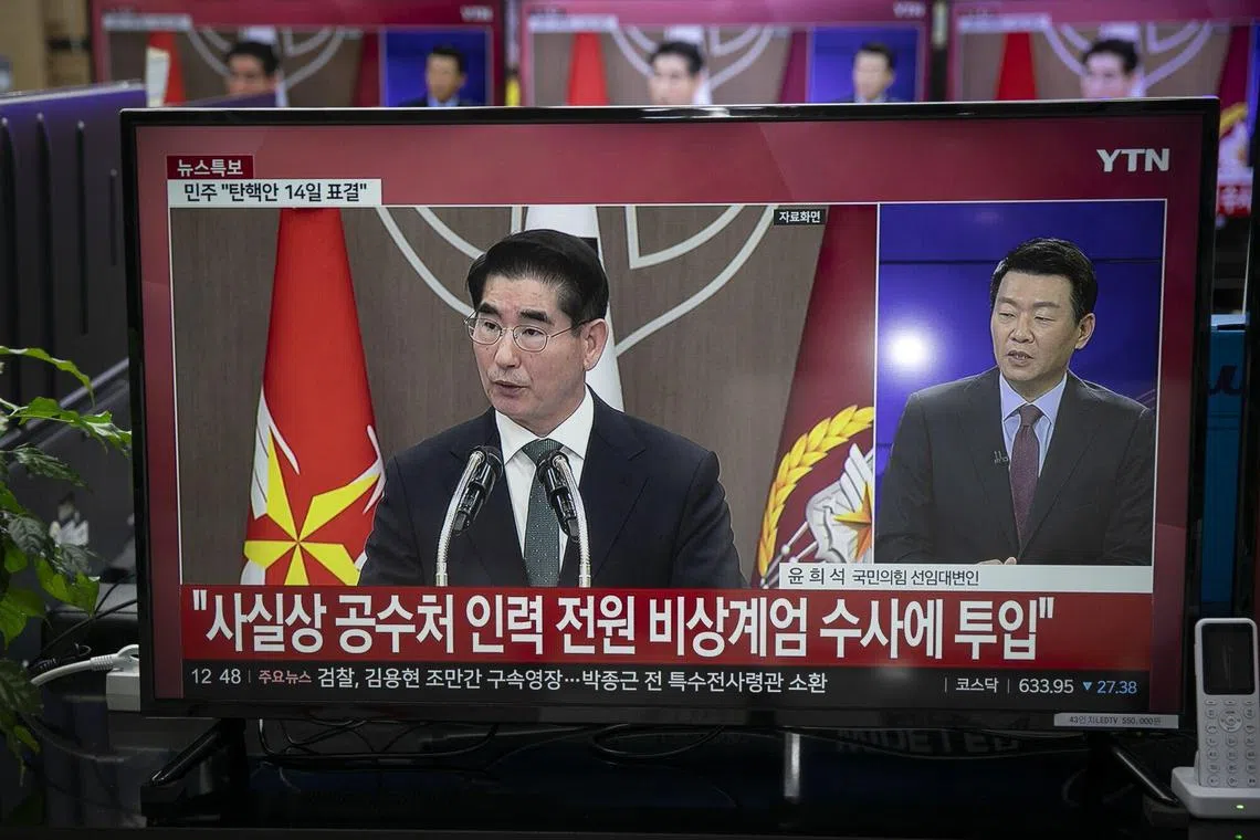 A television screen displays a news report featuring South Korea's former defense minister Kim Yong-hyun, center, at an electronics store in Seoul, South Korea, in Seoul, South Korea, on Monday, Dec. 9, 2024. South Korean police said they are reviewing whether to impose an overseas travel ban on Yoon as they joined a race to investigate the embattled leader over his brief declaration of martial law. Photographer: Woohae Cho/Bloomberg