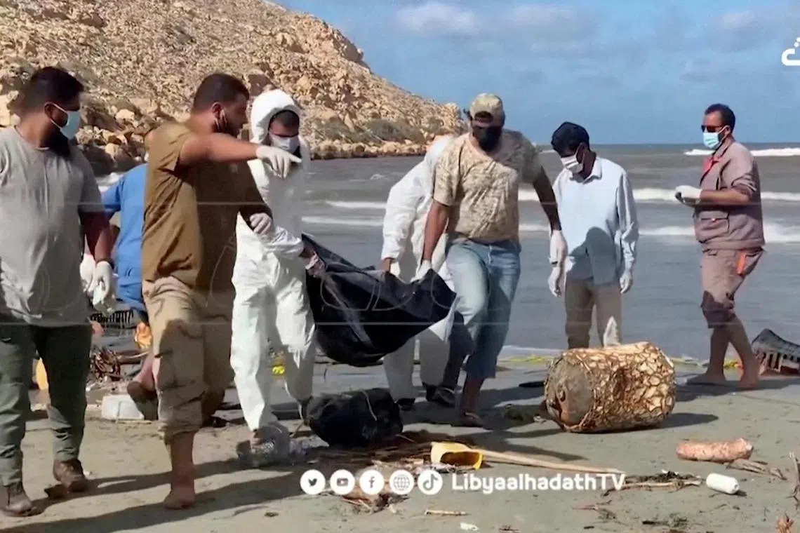 Volunteers carry bodies pulled from the sea, following the deadly floods in Derna.