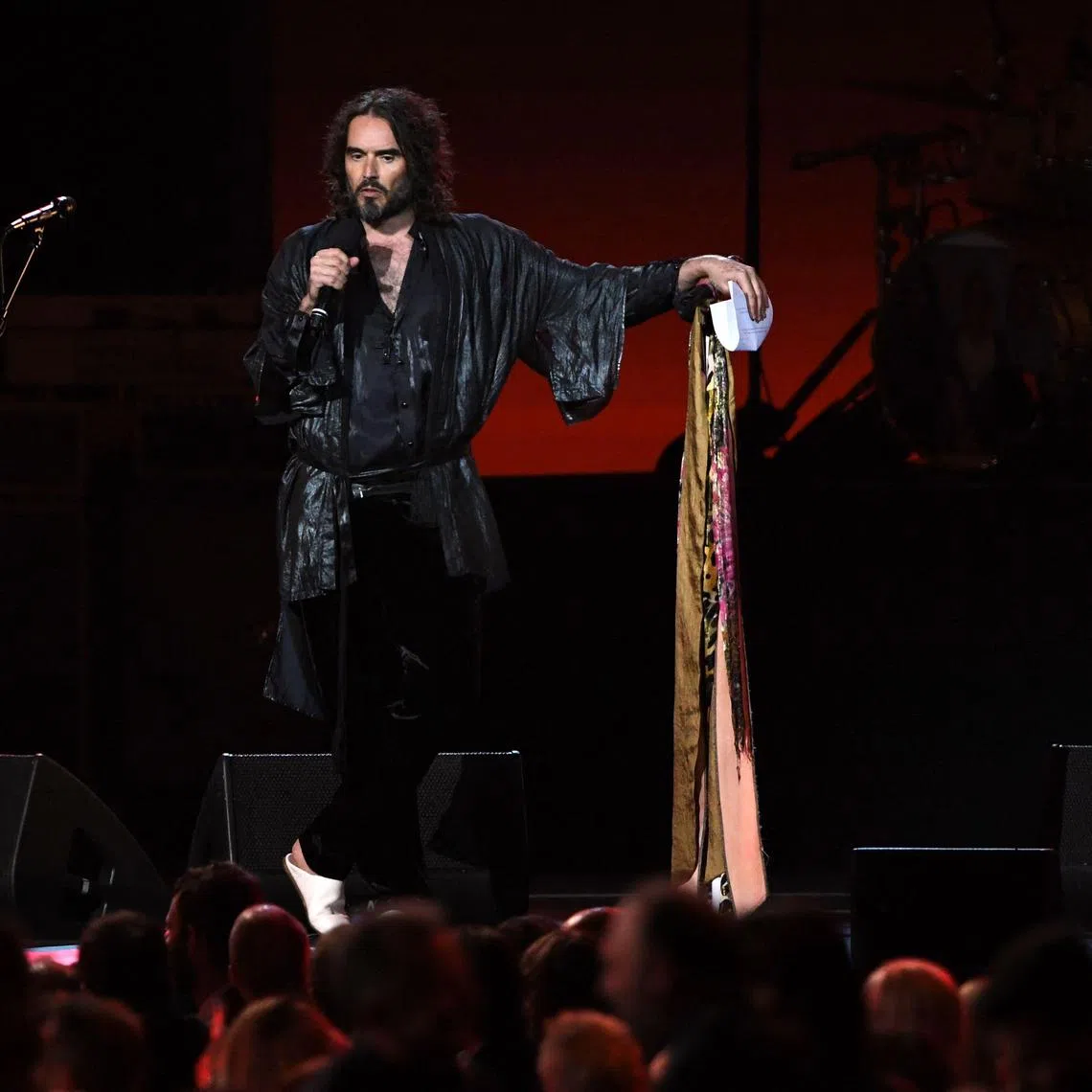 (FILES) Host British actor Russell Brand speaks onstage during the 2020 MusiCares Person Of The Year gala honoring US rock band Aerosmith at the Los Angeles Convention Center in Los Angeles on January 24, 2020. British comedian and actor Russell Brand has been accused of rape, sexual assaults and emotional abuse during a seven-year period, according to the results of a media investigation published on September 16, 2023. (Photo by MARK RALSTON / AFP)