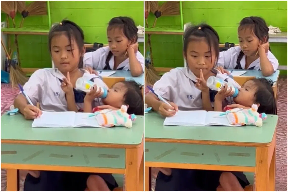 The girl, reportedly a fifth-grade student, was seen feeding her younger sibling while doing schoolwork.