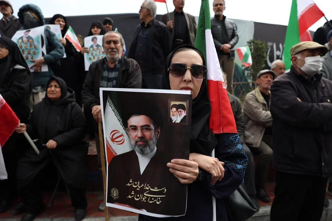 An Iranian woman holding a poster of new Iranian supreme leader Mojtaba Khamenei, who has not been seen by Iranians since his selection on March 8 by a clerical assembly.