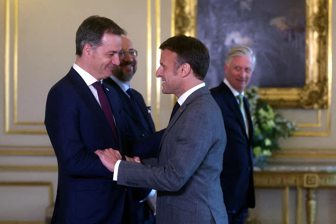 French President Emmanuel Macron is welcomed by Belgian Prime Minister Alexander De Croo (L)  ahead of a special meeting of the European Council in Brussels, Belgium, 17 April 2024. Belgian King Philippe (Back R) and European Council President Charles Michel (Back L)  are seen at the back. OLIVIER HOSLET/Pool via REUTERS