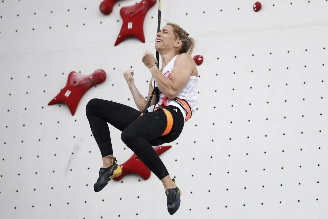 Aleksandra Miroslaw of Poland celebrates winning gold in the speed climbing at the Paris Olympics.
