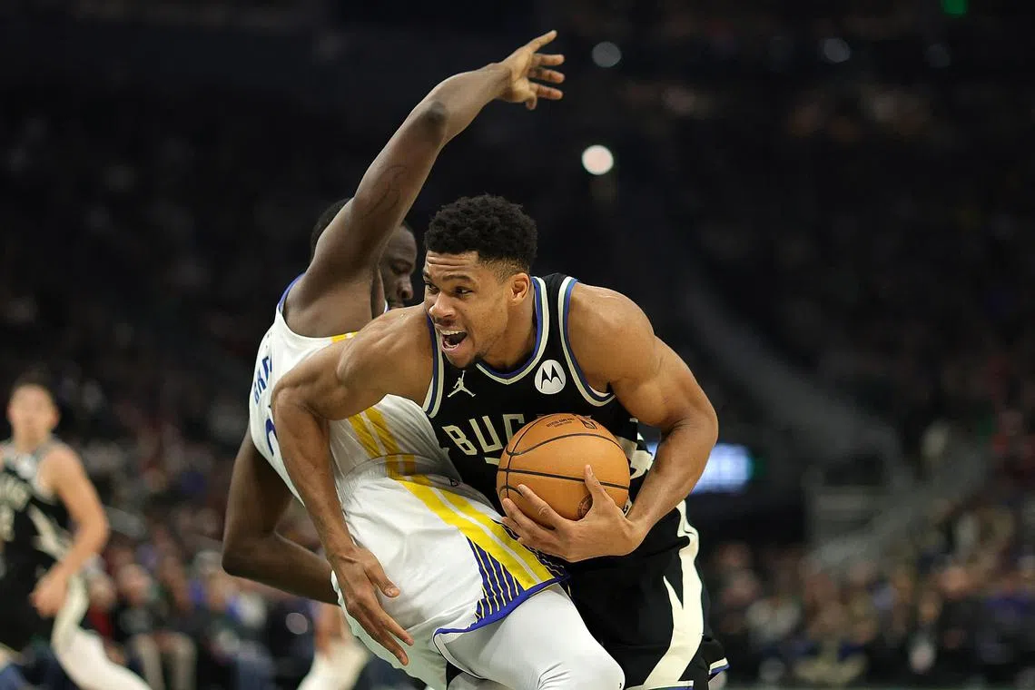 Giannis Antetokounmpo (right) of the Milwaukee Bucks is fouled by Draymond Green of the Golden State Warriors during their game on Tuesday. 